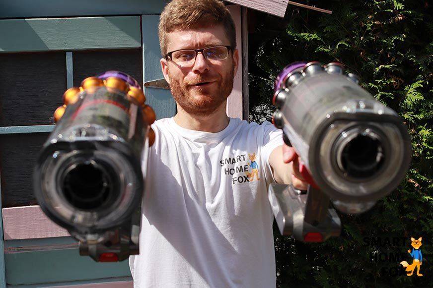 Holding both hand vacuums with outstretched arms